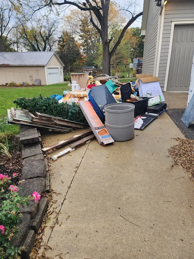 Dumpster being loaded with debris for 12 Yard Dumpster Rental in Freeport